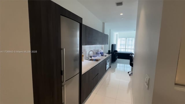 hallway featuring sink and light tile patterned floors