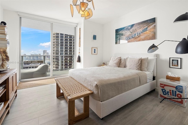 bedroom with hardwood / wood-style flooring, floor to ceiling windows, and access to exterior