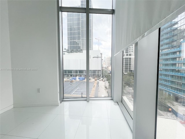 empty room featuring floor to ceiling windows and light tile patterned flooring