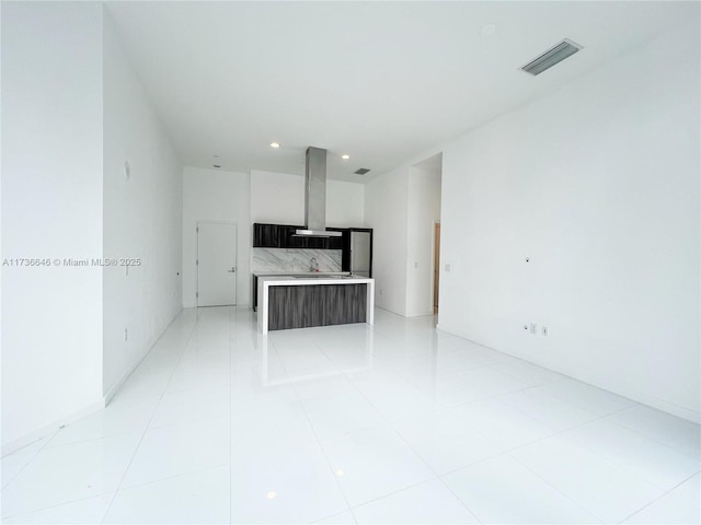 unfurnished living room with sink and light tile patterned floors