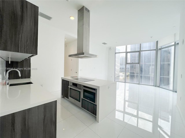 kitchen featuring sink, island range hood, light tile patterned flooring, black electric cooktop, and stainless steel oven