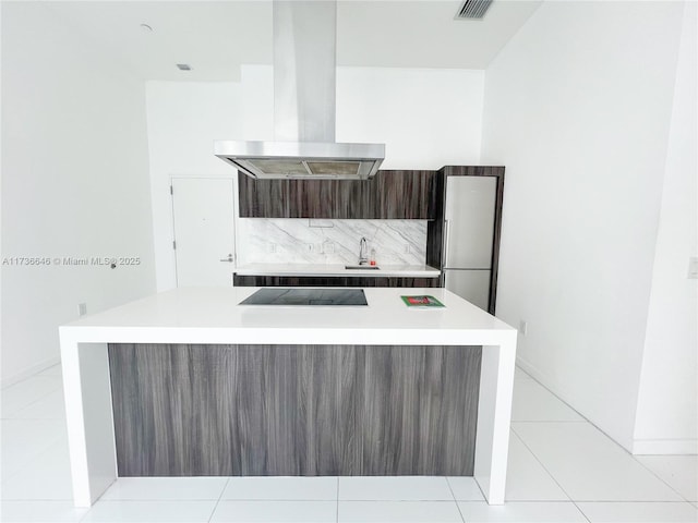 kitchen with black electric stovetop, light tile patterned floors, a kitchen island, and island exhaust hood