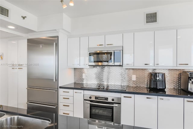 kitchen with backsplash, stainless steel appliances, sink, and white cabinets