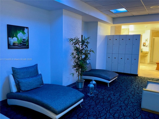 interior space with carpet flooring, mail boxes, and a drop ceiling