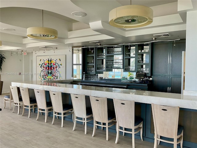 bar with pendant lighting and light wood-type flooring