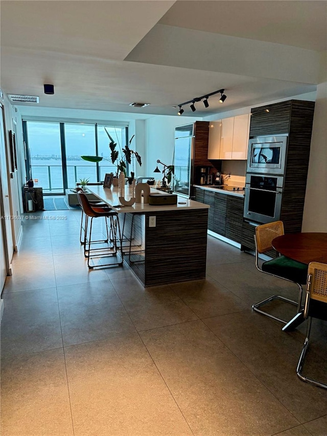 460 NE 28th St Unit 2503, Miami, FL 33137 - kitchen with built in appliances, rail lighting, light countertops, white cabinets, and modern cabinets