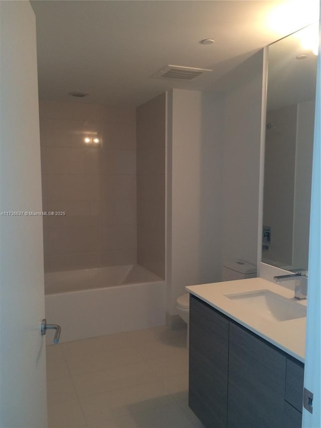 full bathroom with tiled shower / bath, vanity, toilet, and tile patterned flooring