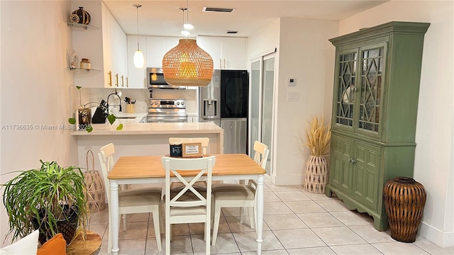 13251 SW 17th Ln Unit B1-22, Miami, FL 33175 - kitchen with appliances with stainless steel finishes, green cabinets, light countertops, a peninsula, and light tile patterned floors