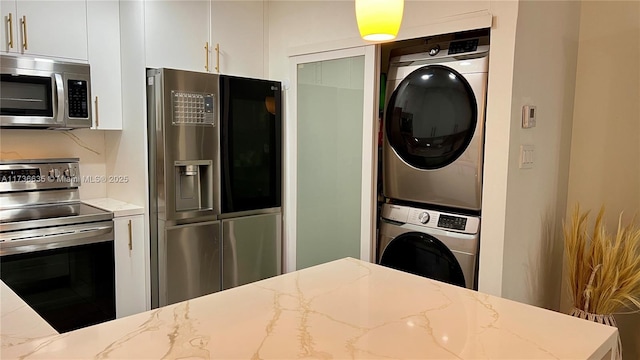 13251 SW 17th Ln Unit B1-22, Miami, FL 33175 - kitchen featuring stainless steel appliances, stacked washer / dryer, white cabinets, and light stone counters