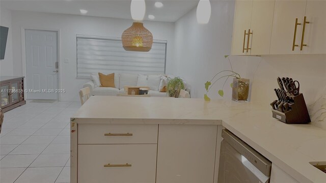 kitchen featuring light tile patterned flooring, hanging light fixtures, stainless steel dishwasher, kitchen peninsula, and light stone countertops