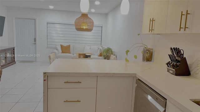 kitchen featuring light stone counters, decorative light fixtures, stainless steel dishwasher, light tile patterned flooring, and a peninsula