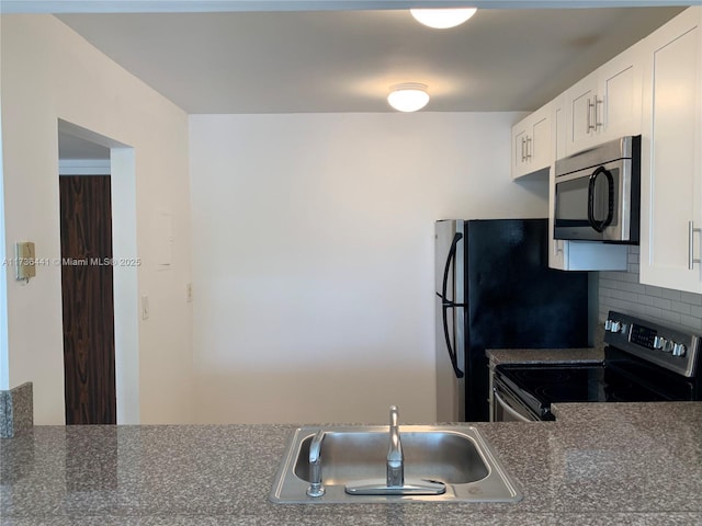 kitchen with stainless steel appliances, tasteful backsplash, sink, and white cabinets