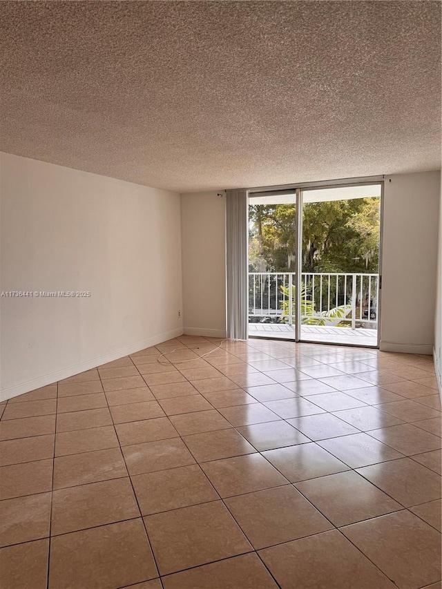 unfurnished room featuring expansive windows, a textured ceiling, and light tile patterned floors