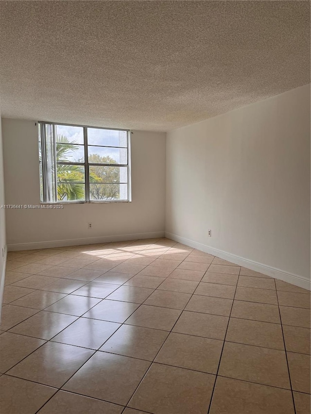 empty room featuring light tile patterned flooring and a textured ceiling