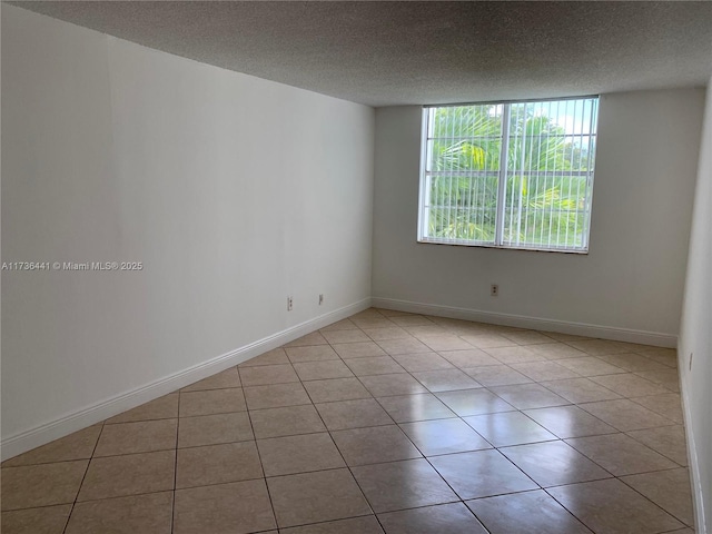 tiled spare room featuring a textured ceiling