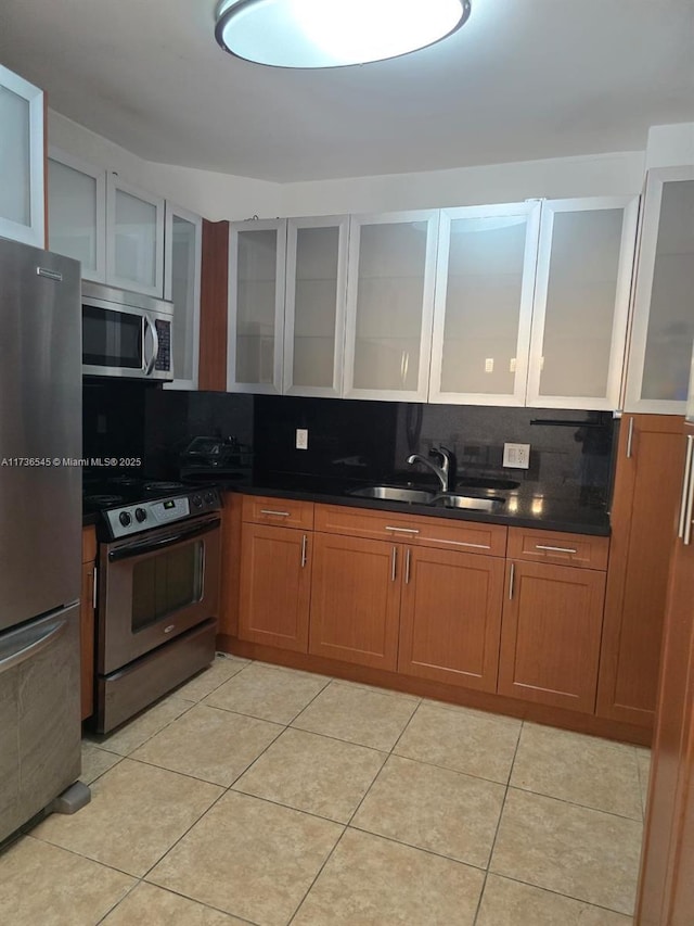 kitchen featuring light tile patterned floors, appliances with stainless steel finishes, sink, and backsplash