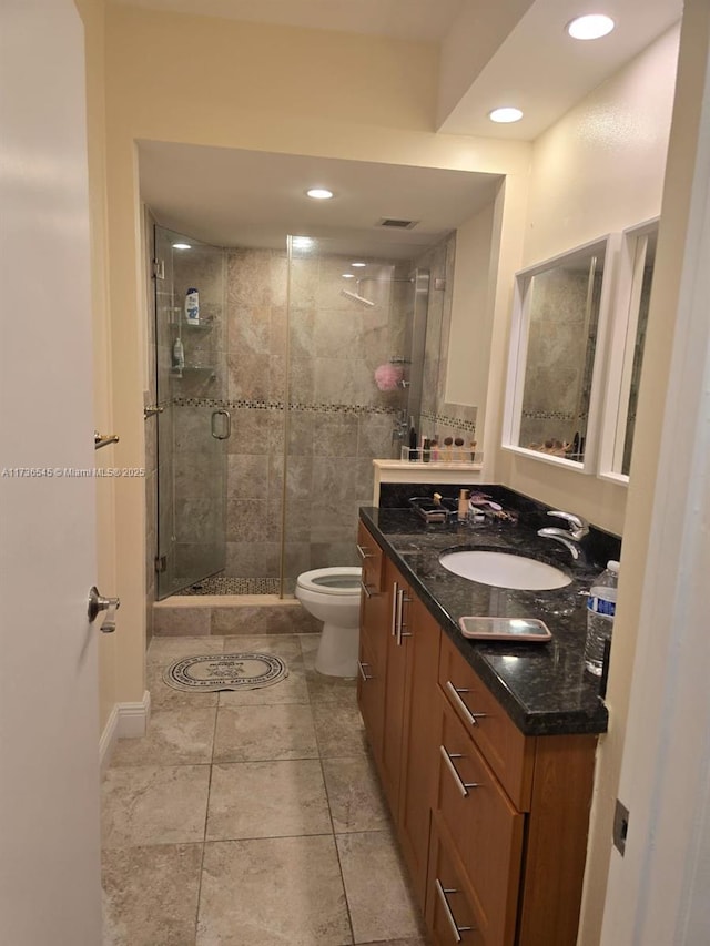 bathroom with a shower with door, vanity, and toilet