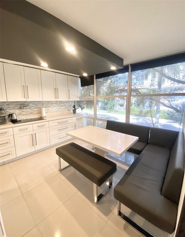 kitchen with tasteful backsplash, light tile patterned floors, and white cabinets