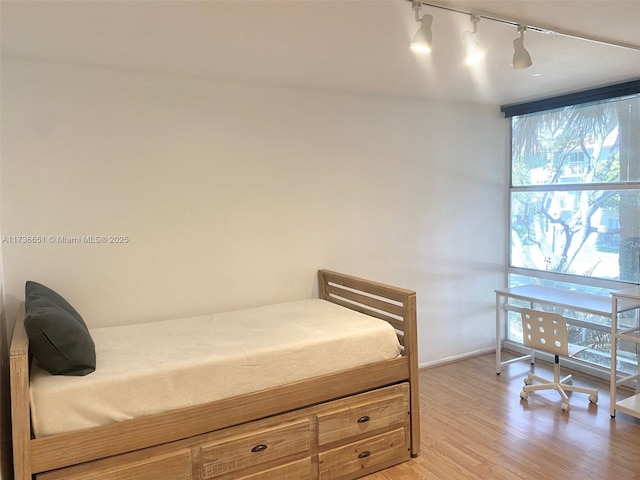 bedroom featuring hardwood / wood-style flooring and floor to ceiling windows