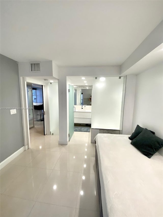 bedroom featuring light tile patterned flooring and connected bathroom