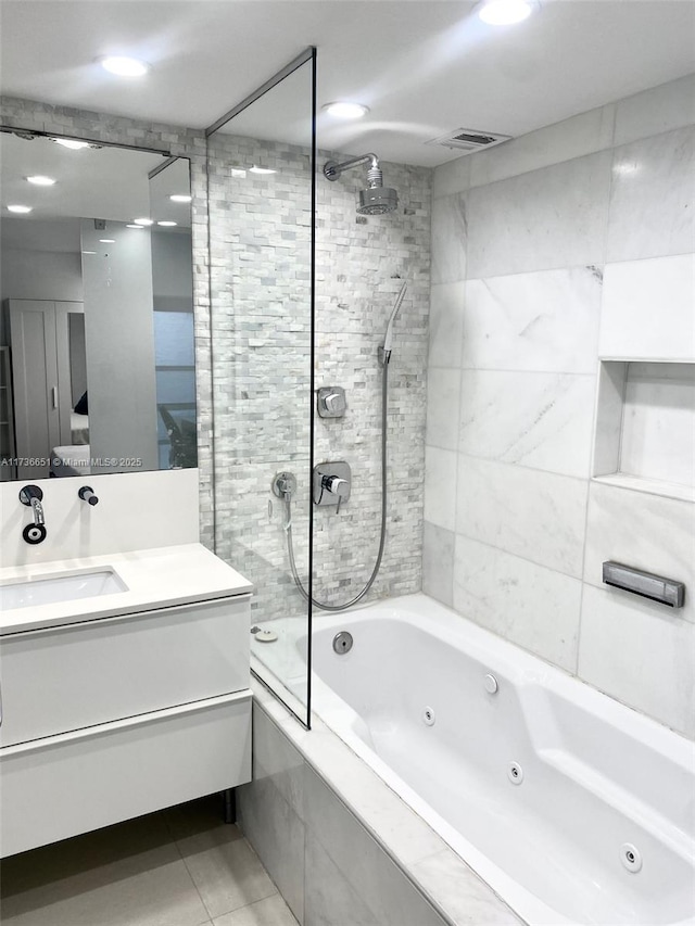 bathroom with vanity, tile patterned floors, and tiled shower / bath