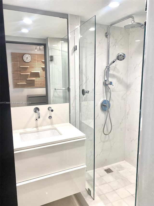 bathroom featuring tiled shower and vanity