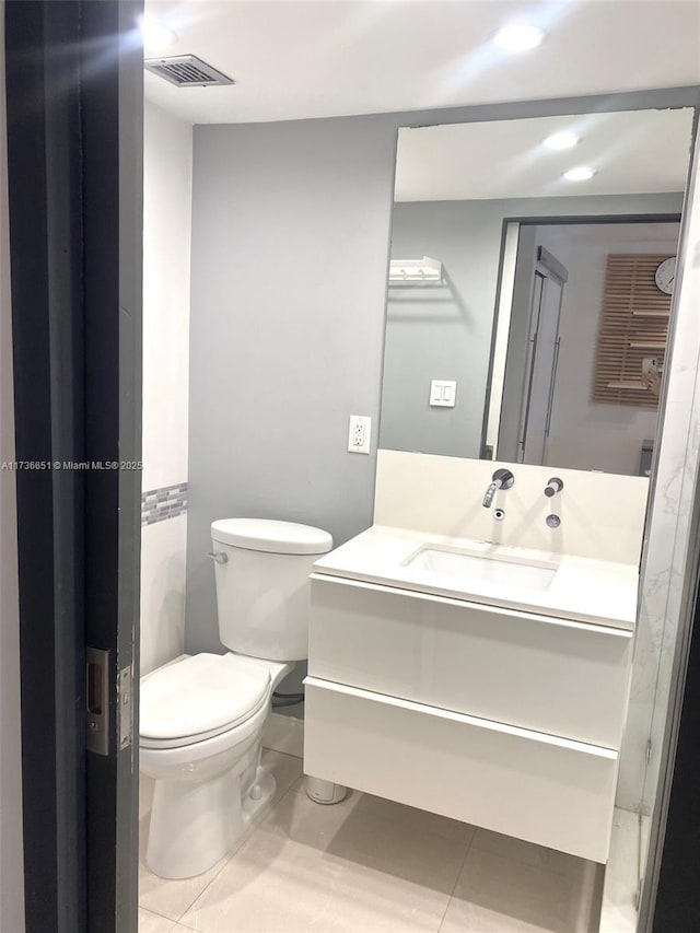 bathroom with vanity, tile patterned floors, and toilet