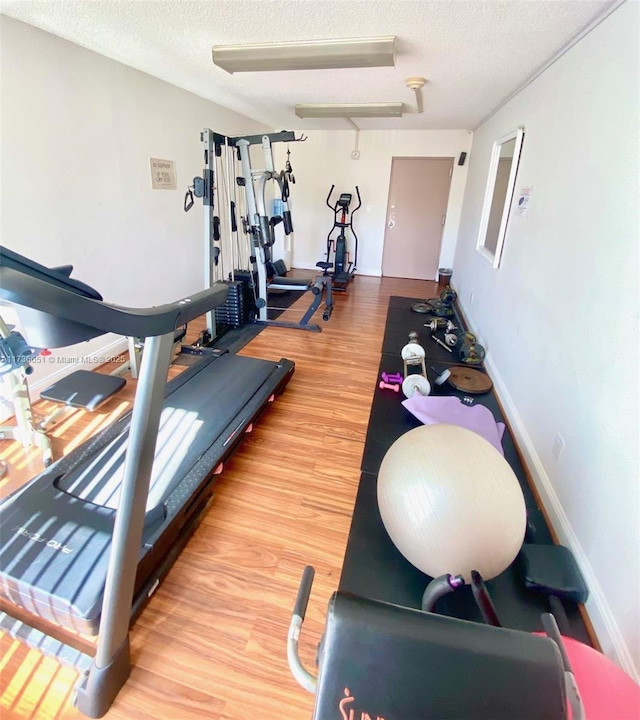 workout area with hardwood / wood-style flooring and a textured ceiling