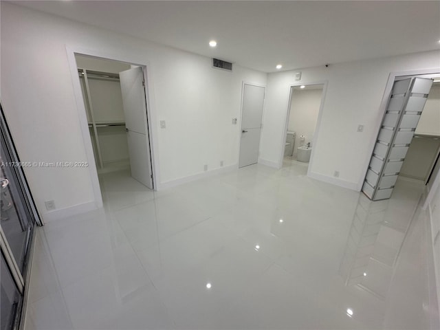 unfurnished bedroom with a spacious closet, visible vents, and a closet