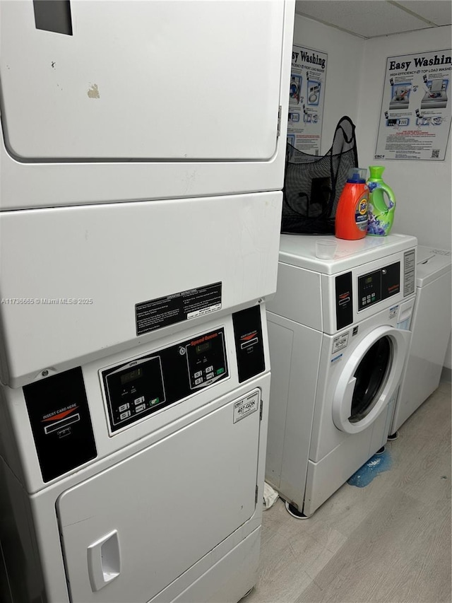 common laundry area with light wood-style floors, stacked washing maching and dryer, and washer and dryer