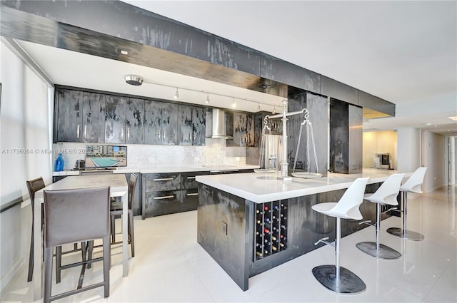 bar with light tile patterned floors, stovetop, backsplash, stainless steel fridge with ice dispenser, and wall chimney exhaust hood