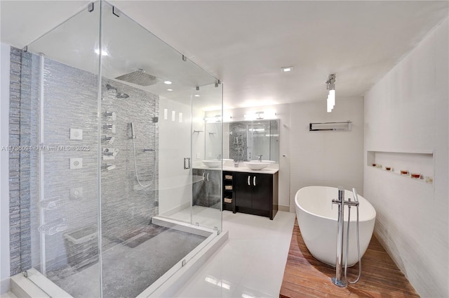 bathroom featuring vanity, hardwood / wood-style floors, and plus walk in shower