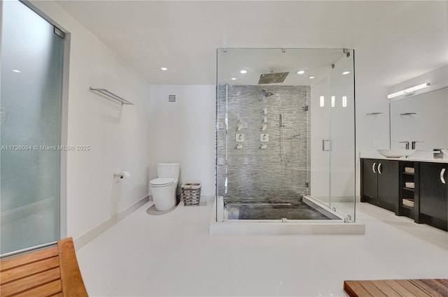 bathroom with vanity, a shower with shower door, and toilet