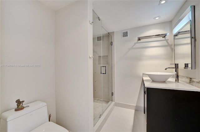 bathroom featuring vanity, an enclosed shower, and toilet