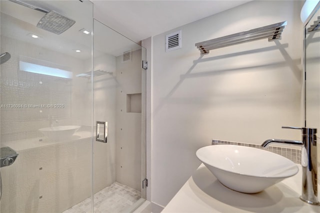 bathroom featuring sink and a shower with shower door