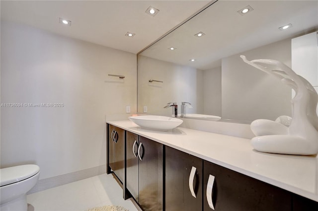 bathroom featuring vanity, tile patterned flooring, and toilet