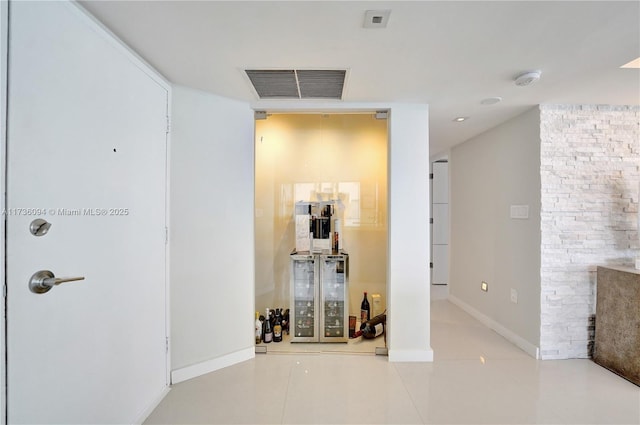 workout room featuring light tile patterned flooring and wine cooler