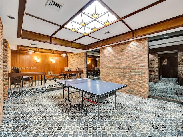 rec room with a skylight and brick wall