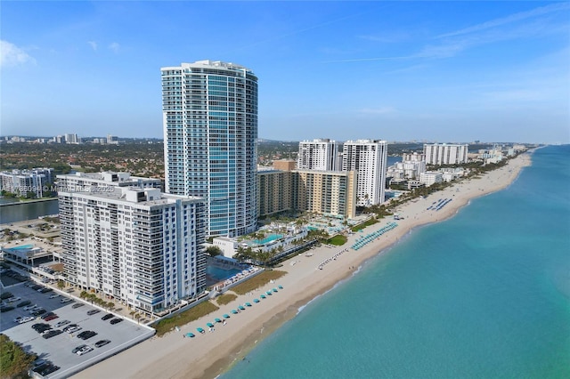 birds eye view of property featuring a beach view and a water view