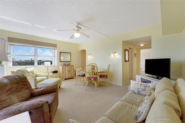 carpeted living room with ceiling fan and a textured ceiling