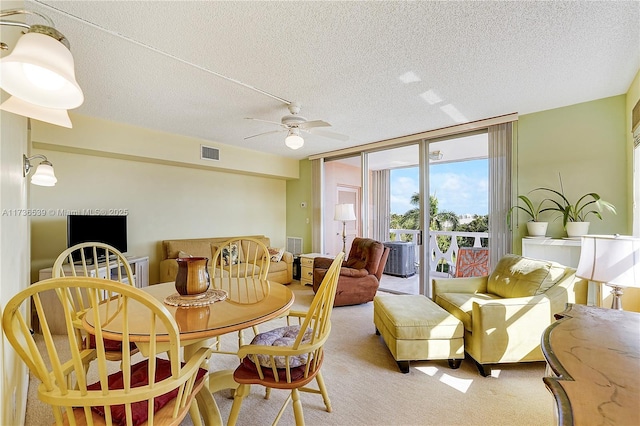 carpeted dining space with ceiling fan, floor to ceiling windows, and a textured ceiling