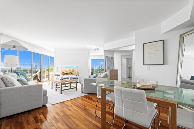 dining area with floor to ceiling windows and hardwood / wood-style floors