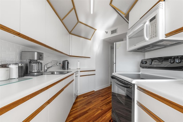 kitchen with sink, white appliances, dark hardwood / wood-style floors, white cabinets, and decorative backsplash