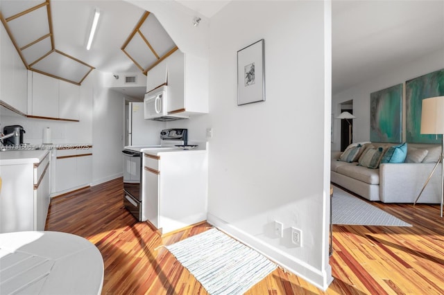 kitchen featuring light hardwood / wood-style flooring, electric range oven, and white cabinets