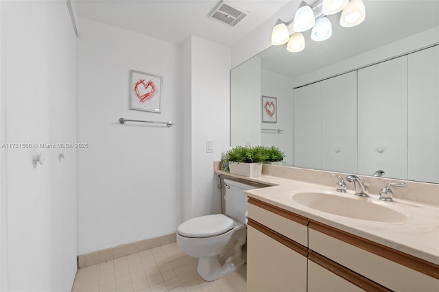 bathroom featuring vanity, tile patterned floors, and toilet