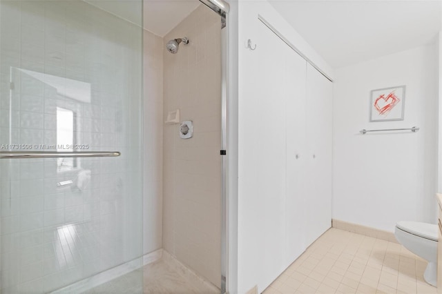 bathroom featuring tile patterned floors, toilet, and an enclosed shower