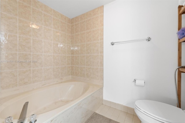 bathroom with tiled bath, tile patterned floors, and toilet