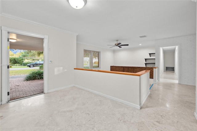 interior space with crown molding, brick wall, ceiling fan, and kitchen peninsula