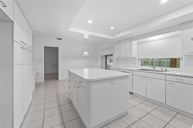 kitchen with a kitchen island, decorative light fixtures, white cabinetry, sink, and light tile patterned floors