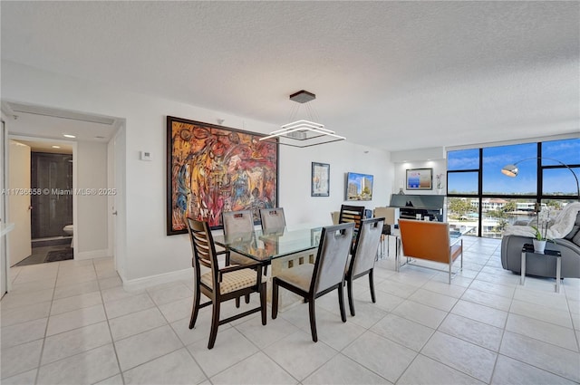 dining space featuring a textured ceiling, a wall of windows, and light tile patterned flooring